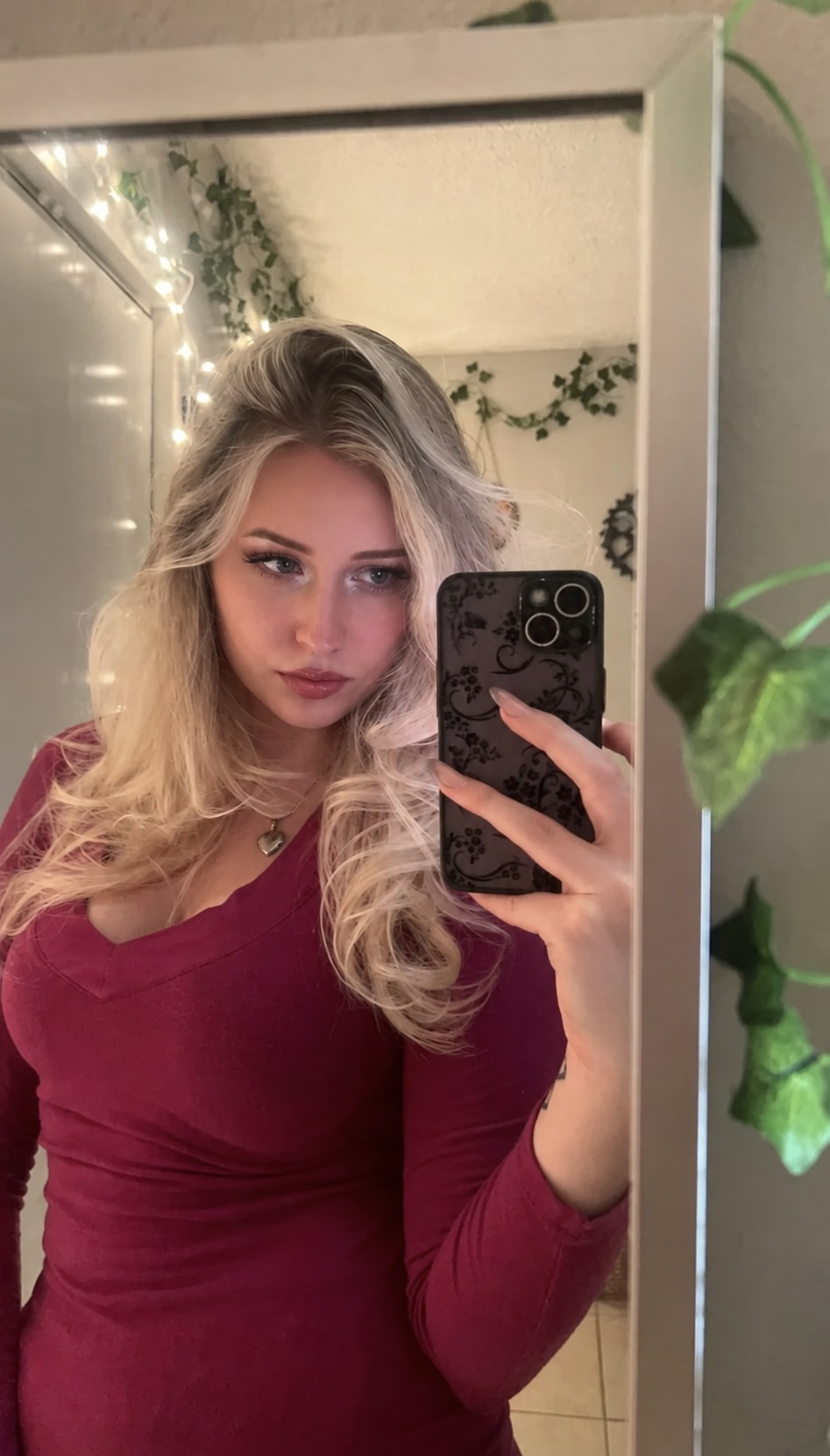 Megan in a burgundy top taking a mirror selfie